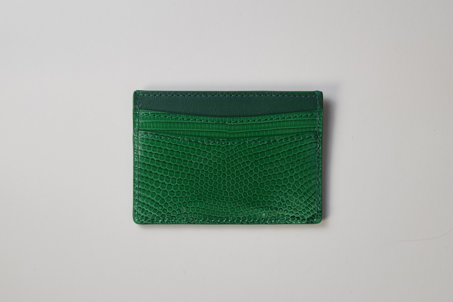 a green card holder on a white surface