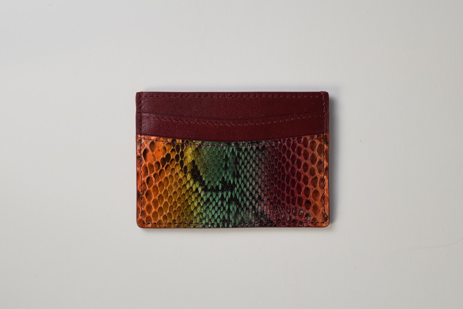 a colorful python skin card holder on a white surface